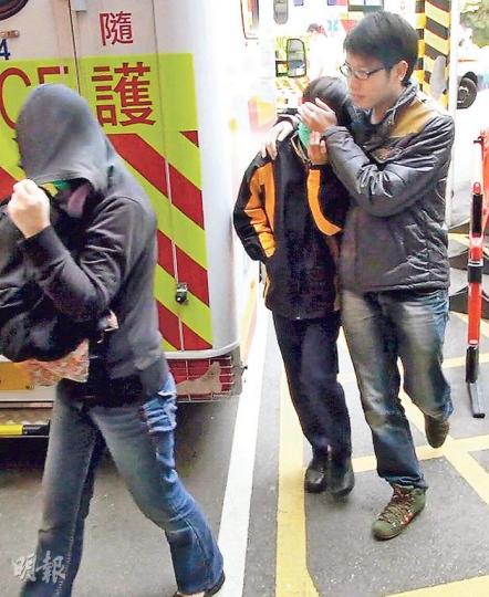 在上課時突然情緒激動，走出課室危坐走廊欄杆的中一男生（中），被教師勸服返回安全地方，由家長及教師陪同送院檢查。（林智傑攝）
