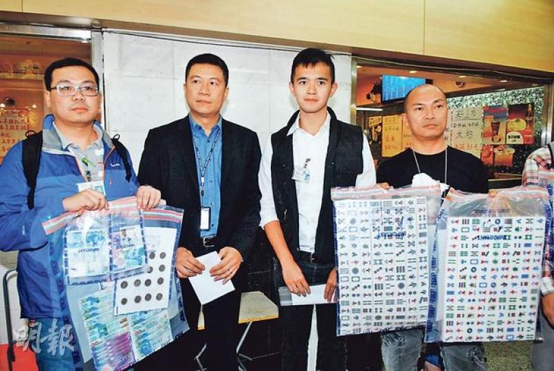 警方展示在筲箕灣非法麻將館內檢獲的賭款、麻將及籌碼等證物。（伍浦鋒攝）警方在筲箕灣東大街一幢住宅大廈閣樓破獲11個商舖涉嫌被租用經營非法麻將賭檔，共檢獲68張麻將枱及拘捕逾百人，全部帶署查問。（伍浦鋒攝）