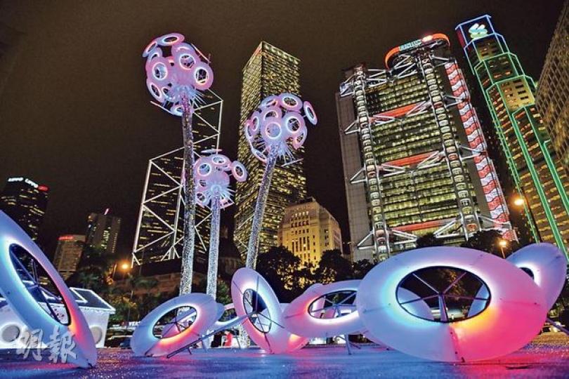 美國設計師Robert Buchholz創作的蒲公英形藝術品《WISH》，70粒「種子」（上圖圓形裝置）共安裝了36,000顆LED燈，在電腦系統的控制下可跟隨音樂變色，甚至同時間顯示各種顏色（如圖）。七彩繽紛的《WISH》，與鄰近商廈的霓虹燈互相輝映。（盧翊銘攝）