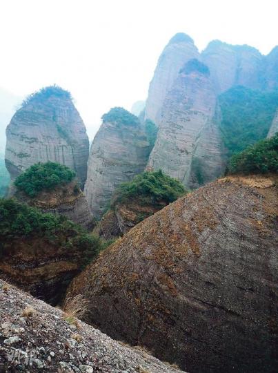 從「空中走廊」可看到對面山下的「五女拜壽」群峰。（水京攝） 沿雙峰間修建的遊覽徑，可到達「一線天」。（水京攝） 財神廟是山上唯一遊客可到的建築物。（水京攝） （水京攝） （明報製圖）