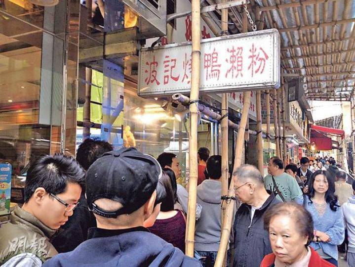 西環波記燒臘粉麵獲米之蓮推介後即大排長龍，連巡邏經過嘅警察都問﹕「呢間嘢點解咁巴閉？」（張煒明攝）