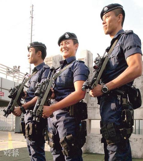 同袍稱她為「阿油」的葉君幼（中）是機場特警組中少數的女特警，加入警隊前曾為三項鐵人運動員，亦曾在亞洲錦標賽中奪得銀牌。（林俊源攝） 機場特警進行模擬實戰演練，模擬有政要訪港時在機場受到持槍匪徒襲擊。特警身穿今年最新購入的訓練服，無論在耐火力和耐磨度方面均有增強。（林俊源攝） 機場特警平日會佩戴30多磅裝備訓練，如攀爬鐵架以鍛煉負重下的活動靈活性，圖為特警戴頭盔及機槍等重裝備訓練。（林俊源攝）