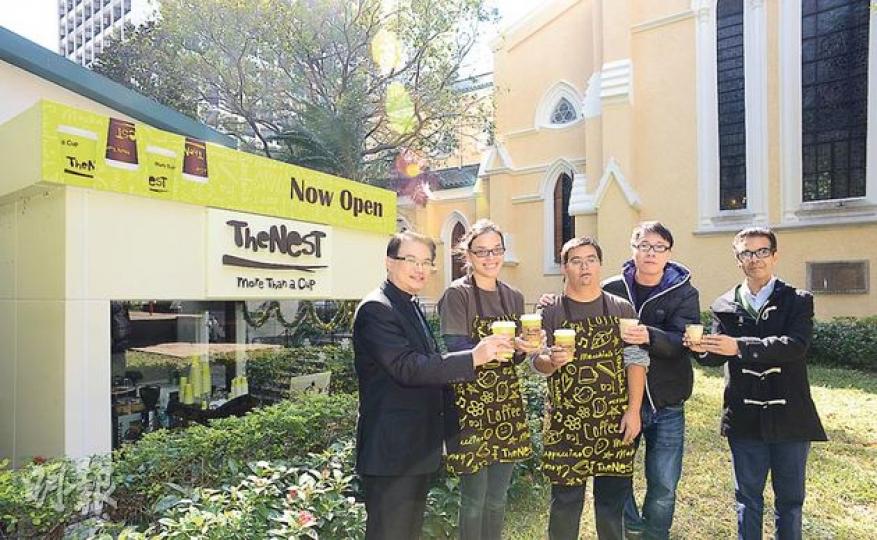 聖約翰座堂（圖後建築）與思拔中心合作，花4年設立咖啡店「The Nest」（圖左）。座堂主任牧師謝子和（左一）、中心總幹事潘恕達（右一）與兩名分別患有學習障礙及唐氏綜合症的受訓店員Jane（左二）、Josh（中）及健全店長家豪（右二）於店外草地展示該店的愛心咖啡。 （陳淑安攝） 社企咖啡店「The Nest」現聘有4名正接受咖啡師訓練的學習障礙店員，包括Josh（左一）及Jane（右）。二人都表示熱愛工作，Josh一星期工作6天，Jane更同時於兩間咖啡店工作。（陳淑安攝）