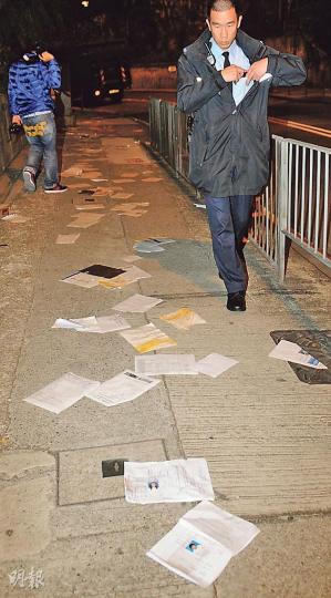 西環堅道近西摩道街頭昨凌晨散佈了數百張文件，當中包括香港科技專上書院學生及舊生的大量個人資料，有途人發現文件後報警，警員到場調查兼將文件逐份檢走。（蔡方山攝）