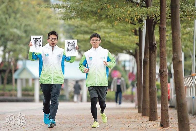 為紀念與愛犬逝世前溜狗時刻而成立的「死狗跑步會」，創辦人曹樂添（Tim，左）過去參加渣打香港馬拉松時，會舉起愛犬Chris和Hugo素描畫。其友人羅永康（Billy，右）會穿上印有愛犬Coco的燙畫T恤。（李澤彤攝）