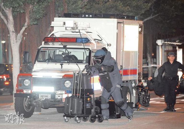 身穿防爆裝的警方爆炸品處理組人員到場引爆「詐彈」，證實內裏並無火藥成分。（蔡方山攝）