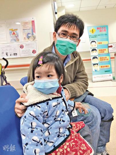 上周四帶同發燒3歲女兒（前）到威院急症室求診的梁先生（後）認同，加價可減少部分非緊急病人到急症室，加上醫療成本上升，「用者自費」也合理，他認為可加價至180元，因較貼近私家醫生水平。（梁杏怡攝）
