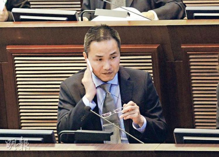 在立法會財委會工務小組委員會會議上，廣播處長鄧忍光遭建制派議員連番批評，一度除下眼鏡抹汗。他指如港台新大樓計劃推倒，要再花兩年重新招標，造價或較現時更高。（余俊亮攝）（明報製圖）