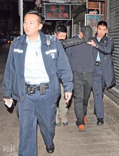 疑以「假大牛」付肉金的召妓南亞漢（蒙頭者）被捕後由警員押返警署扣查。（蔡方山攝）報警指嫖客以500元偽鈔付肉金的女子，事後由女警陪同到警署助查。（蔡方山攝）