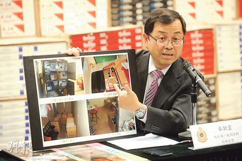 香港海關稅收及一般調查科高級監督麥凱雲在記者會中，展示貨車內藏私煙夾層的照片。（鍾炳然攝）