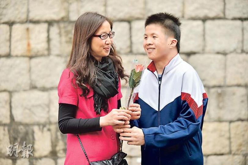 中度智障的19歲青年洪永佳（右），經歷父親生病及離世漸學習獨立，助人為樂令他贏得本年度「青苗十大進步獎」。圖為永佳向獨力照顧他的母親獻上鮮花，答謝親恩。（鄧宗弘攝）