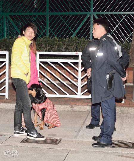 遭兩名冒警男子行劫的男事主（黃衣）及妻子在現場協助警方調查。（蔡方山攝）