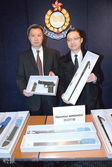 有組織罪案及三合會調查科警司郭耿誠（左）及總督察游乃強（右）展示行動中搜出的大批武器，包括刀及氣槍等。（丁灝嵐攝）