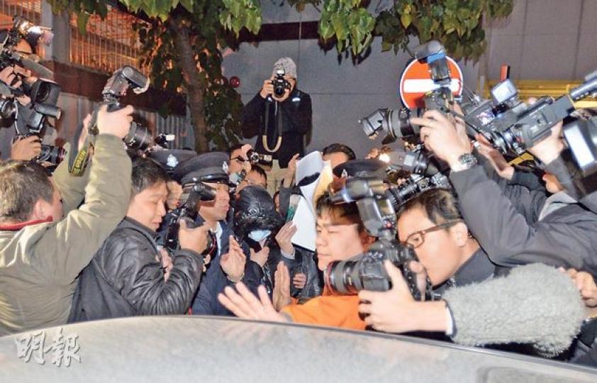 被告羅允彤（中，戴口罩者）甫離開法院，便走向正在附近等候的一輛私家車，卻被大批攝影記者包圍。短短數十米的路程，她用了約15分鐘才能登車，該車要再花約15分鐘才能駛離現場。（盧翊銘攝）
