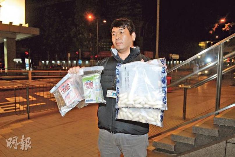 警員在一名尼日利亞男子攜帶的兩盒鮮奶（左）中找到一批粉狀可卡因，料價值逾百萬。（伍蒲鋒攝）警方破獲「鮮奶盒運毒」，拘捕一名尼日利亞男子，在其所攜的兩包盒裝鮮奶內檢約1公斤懷疑可卡因毒品，市值約116萬元。（伍浦鋒攝）