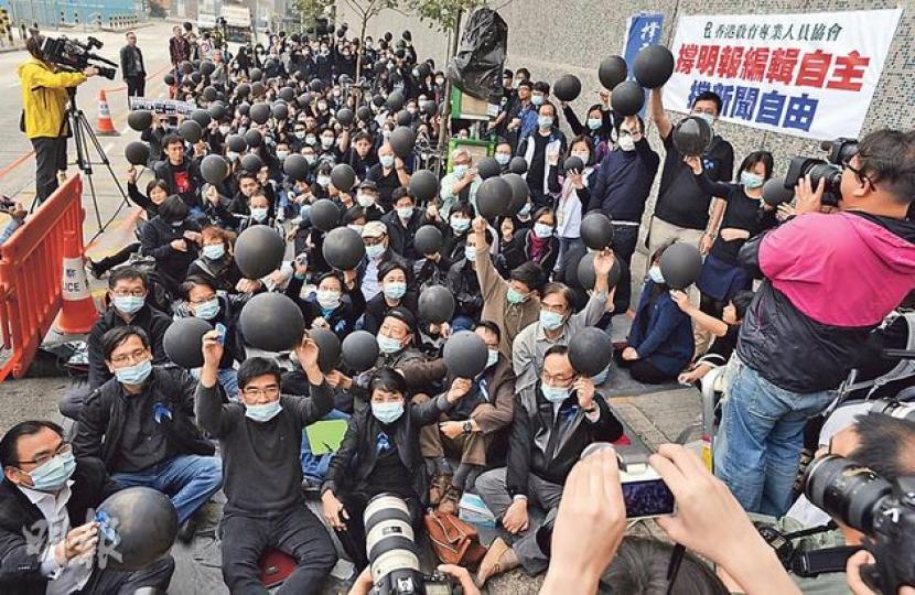 由明報前員工組成的「明報舊生會」，昨在柴灣明報工業中心門外，舉行主題為「雨來傘擋、撐明報、撐新聞自由」集會，逾200市民響應到場參與。參與者集體刺破黑氣球寓意「趕走烏雲見日月」。（余俊亮攝）參與「明報舊生會」集會的兩名學生（左三，中五學生陳學軒；右三，教育學院一年級學生何昆洛）在教協會長馮偉華（左一）及總幹事葉建源（右一）陪同下，於集會尾聲時將兩張寫有「編輯自主」及「新聞自由」的揮春，贈予明報舊生會代表陳健佳（左二）和明報編輯部員工談誦言（右二）。（余俊亮攝）80年代曾擔任《明報》督印人的吳靄儀