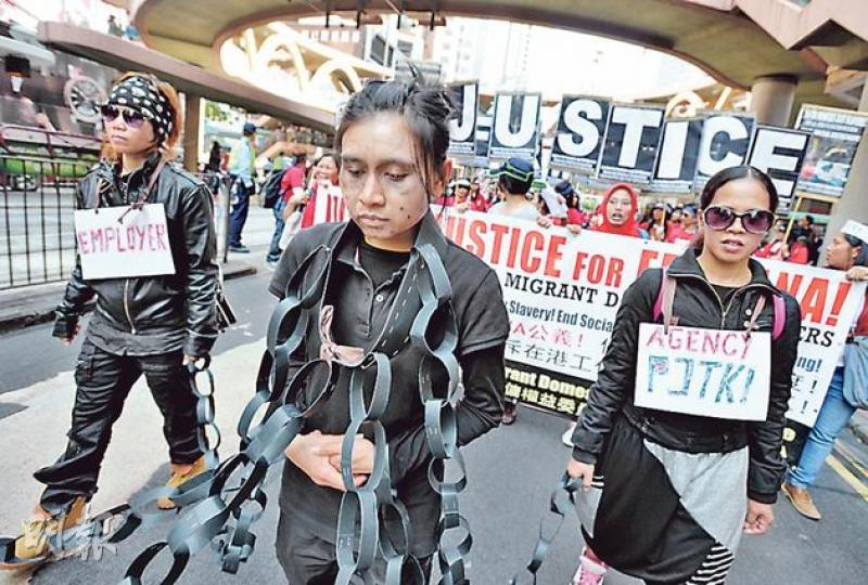 大批外傭昨由維園出發，遊行至銅鑼灣印尼駐港總領事館遞交請願信，部分人戴上假鎖鏈，要求印傭毋須經中介公司簽訂僱傭合約；外傭亦遊行至懷疑被虐印傭Erwiana的中介公司，表達不滿。（盧翊銘攝）
