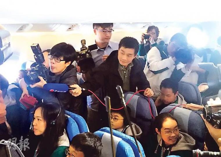 噚日國泰邀請約20多個記者上飛機採訪低收入家庭第一次搭飛機，不過機艙環境擠迫，記者難埋身，好彩幫梁振英開路嘅G4警員（中間持咪者）肯幫電視台記者舉咪收音。（梁卓怡攝）