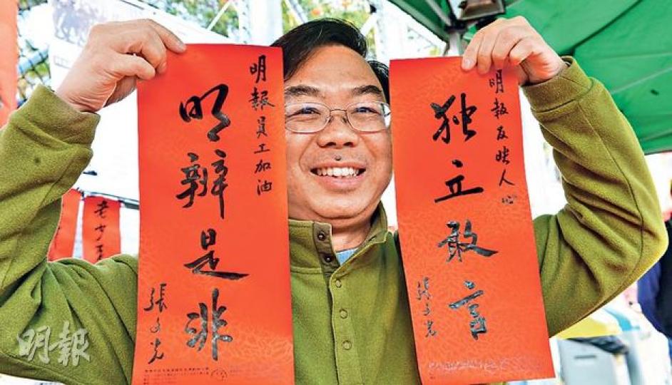 張文光噚日喺支聯會維園年宵攤位寫揮春,為咗支持《明報》員工,即席寫咗「明辨是非 獨立敢言」,為員工打氣。(劉焌陶攝) 張文光噚日喺支聯會維園年宵攤位寫揮春,為咗支持《明報》員工,即席寫咗「明辨是非 獨立敢言」,為員工打氣。(劉焌陶攝)