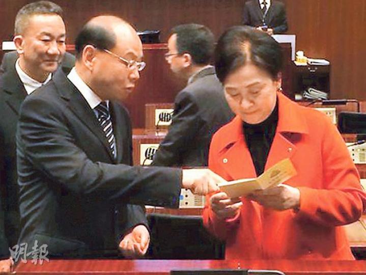 噚日曾偉雄（前左）心情唔錯，仲送咗本有關家暴嘅書畀卿姐（右）。原來呢本書係2010年印製，已係幾年前嘅事，後左係刑事及保安處長羅夢熊。（張煒明攝）
