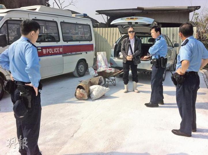 村民在記者面前挖出一具豬屍後，即場致電警署舉報，有警員到場了解。記者其後向豬場負責人陶先生（右三）查詢，他否認埋豬屍。（明報記者攝）