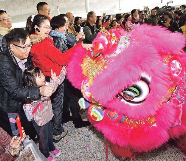 不少市民昨趁年初一乘搭飛機離港度歲，機場晨早人頭湧湧。旅行社則出動財神、舞獅助興（圖）、抽獎派利巿，充滿節日氣氛。（李紹昌攝）有旅行社昨特意安排「財神爺」到機場，為出團的領隊及當值員工打氣之餘，更向報團團友派利巿，祝願人人「馬年行好運」。（李紹昌攝）