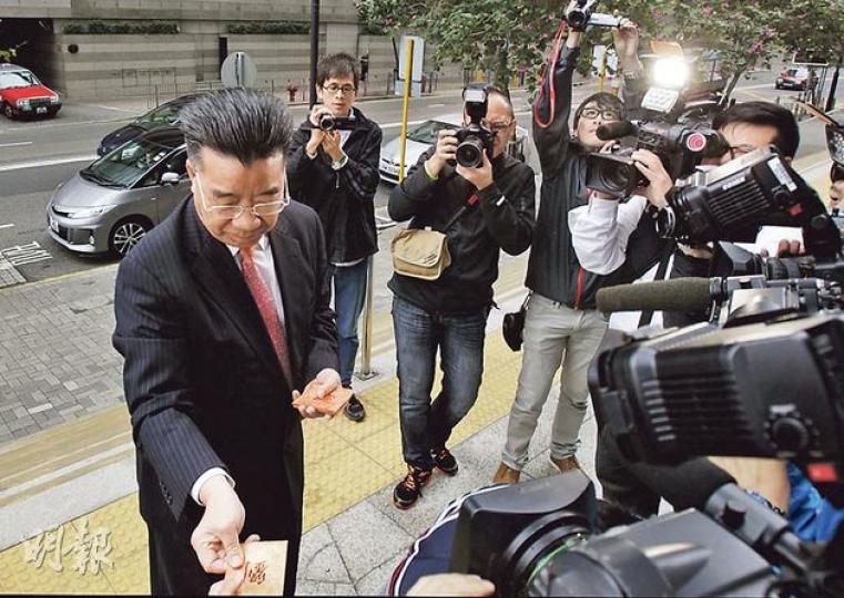 前全國政協委員劉夢熊（左）昨就妨礙司法公正案到區院應訊時，特地戴上紅色領帶「應節」，更向在場攝記派發每人100元利市。本報收到的一封利市將全數捐予慈善機構。（李澤彤攝）