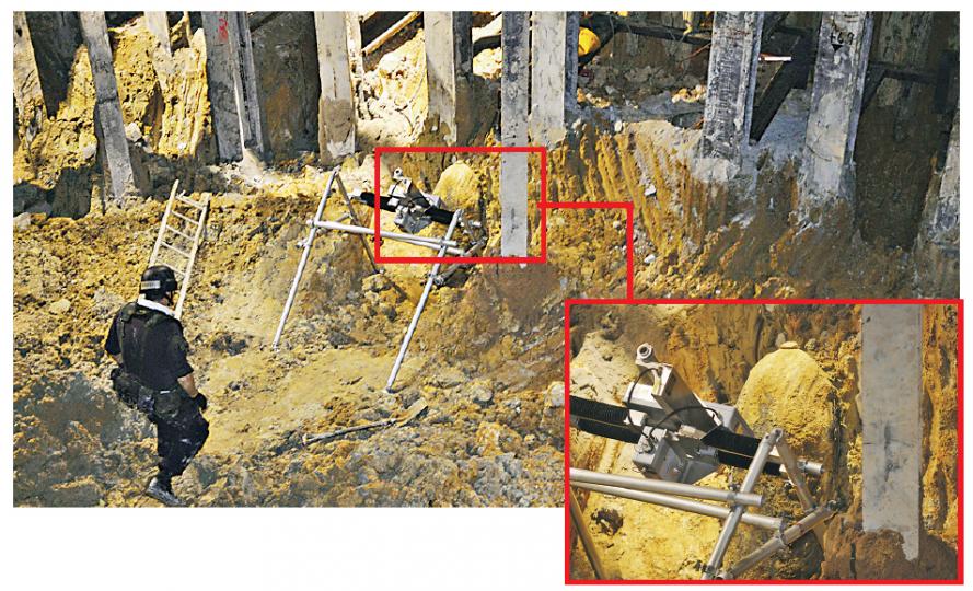 跑馬地地盤發現的戰時炸彈含有高達1000磅黃色炸藥，爆炸品處理組人員要先在炸彈附近用人手挖出坑道，令炸彈外露，再以水力磨砂機切割炸彈，取出炸藥。（余俊亮攝）