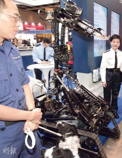 警方展出的拆彈機器人「威霸龍」體積較大，即使路面狀况欠佳仍能平穩行走。（郭慶輝攝）警方昨參與教育及職業博覽招募時，派出爆炸品處理組吸引應徵者。該組的後備處理隊高級督察李伯豪（圖）親身展示一件重70磅的防爆衣。（曾安迪攝）