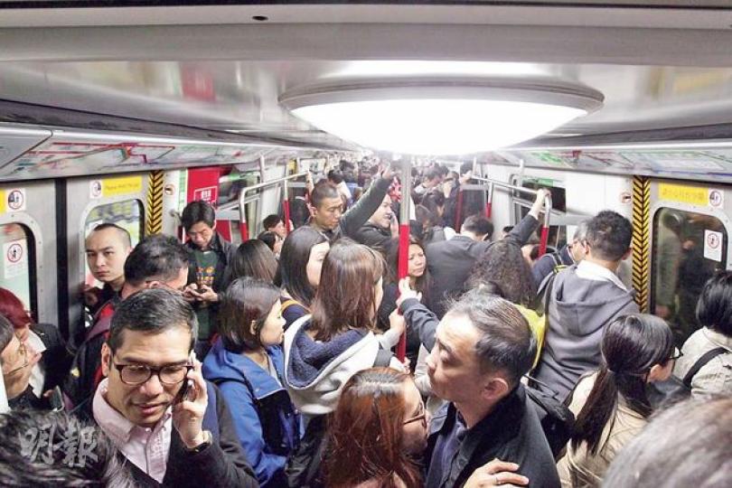港鐵列車在繁忙時段十分擠迫，本報記者量度車廂兩邊車門之間的企位，左右車門相距3米、車門闊約1.8米，面積約5.4平方米的車廂空間。昨午5時半抵達金鐘的列車上，該空間站滿25人（照片顯示其中22人，另有3人站在邊緣未有入鏡），即每平方米站了4.62人，十分擠迫。（郭慶輝攝）