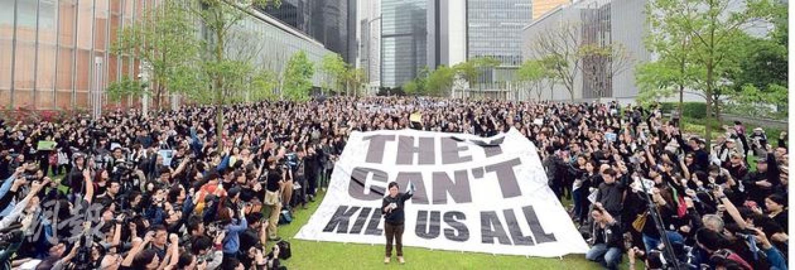 800名新聞從業員及市民,昨於遊行開始前在政總對出的添馬公園,出席記協發起的默站行動。記協主席岑倚蘭(圖正中)於默站後,帶領眾人高舉手中藍絲帶,宣讀「在暴力當前,絕不退縮」等6點宣言。(盧翊銘攝) 800名新聞從業員及市民,昨於遊行開始前在政總對出的添馬公園,出席記協發起的默站行動。記協主席岑倚蘭(圖正中)於默站後,帶領眾人高舉手中藍絲帶,宣讀「在暴力當前,絕不退縮」等6點宣言。(盧翊銘攝)