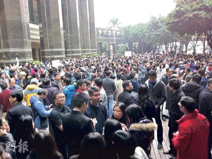 灣仔政府大樓電梯機房昨早起火冒煙，大樓內數百人疏散到附近空地。（羅慧茵攝）灣仔政府大樓頂樓電梯機房昨日起火冒煙，13人一度被困升降機內，消防員接報到場救援。（羅慧茵攝）