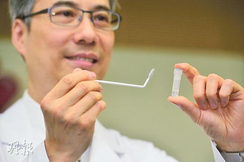 多倫多大學醫學院耳鼻喉頭頸外科學系副教授吳憲威，展示檢測鼻咽癌所需的刷子，該刷子外形如「牙縫刷」，刷頭設有多個微孔，以便收集鼻咽細胞，細胞的基因樣本在溶液中（右）可保存30天。（黃志東攝）（明報製圖）