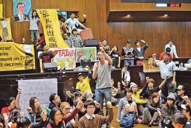 學生佔領立法院昨日已進入第三天，學生向總統馬英九發出最後通牒，促他今午前展開對話。（盧翊銘攝）昨日的台北有雨，但無數身穿雨衣的學生仍堅守陣地。（盧翊銘攝）有民眾給立法院門外的示威者送來向日葵，主持人形容每人手持一枝向日葵有如「民主遍地開花」。（盧翊銘攝）六四學生領袖吾爾開希（台上舉手者）加入佔領立法院學生隊伍，並上台發言。（盧翊銘攝）