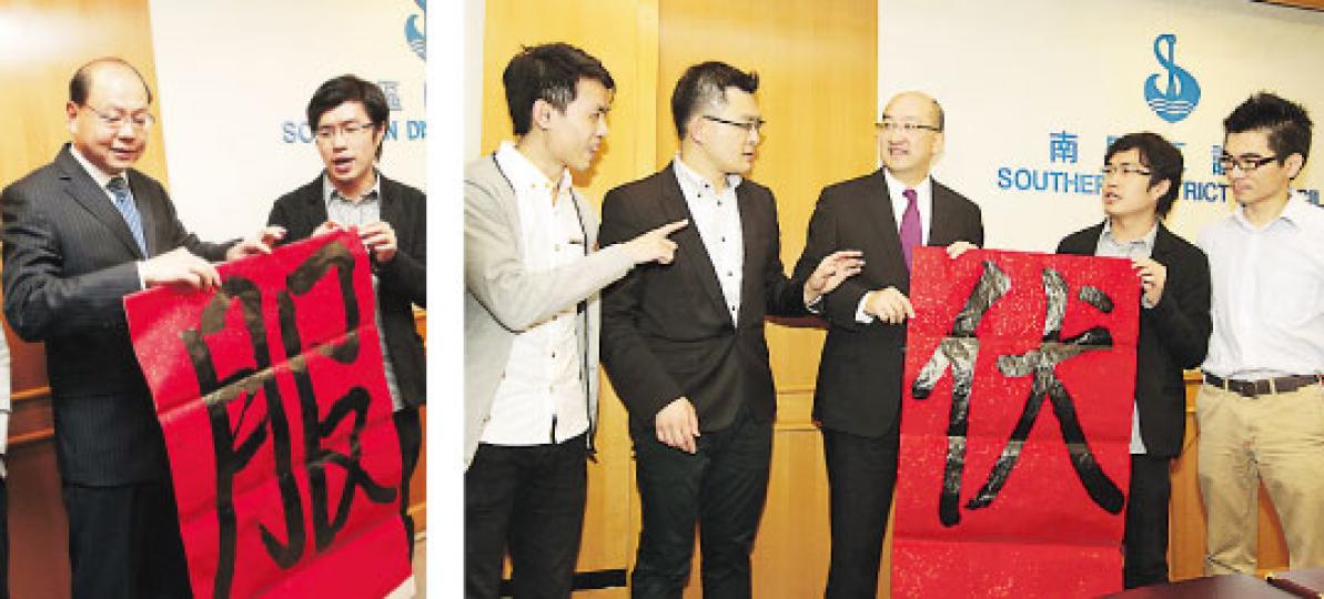 區議員區諾軒送咗個「服」字畀一哥曾偉雄（左圖左），話服咗佢近來連番失言。民主黨一班「乳鴿」一齊送個「伏」字畀政制及內地事務局長譚志源（右圖中），諷刺如果跟京官意思去通過政改，港人一定「中伏」。（郭慶輝攝）