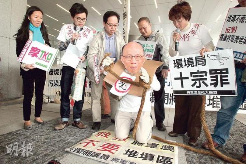 立法會環境事務委員會昨舉行公聽會，西貢區議員方國珊（右）帶領居民到立法會外請願，有居民扮作環境局長黃錦星下跪，批評他強行把擴建堆填區推上馬。（林俊源攝）（明報製圖）