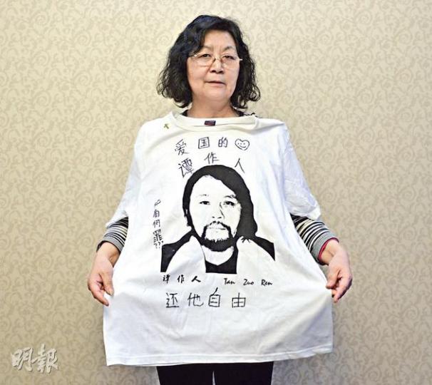 王慶華昨在成都接受本報專訪時，展示一件藝術家艾未未為譚作人製作的T恤，當年艾未未曾穿著這件衫聲援被捕的譚作人。艾將之轉贈給譚家，當年僅16歲的譚作人小女兒曾穿著它在四川大學「散步」，上面寫着「還他自由」。（余俊亮攝）