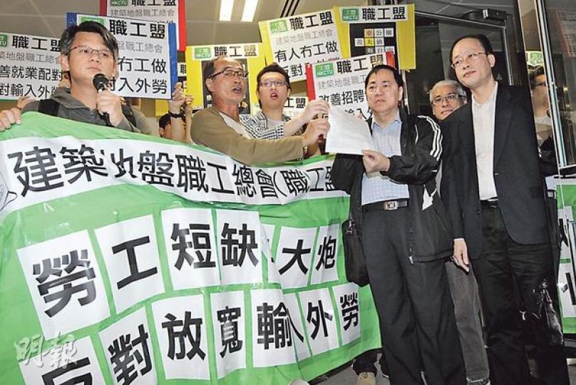 職工盟昨日在勞顧會召開會議前在勞工處門外請願，不滿政府「放寬」輸入外勞，並向勞顧會勞方委員梁籌庭（前右二）遞交請願信。右一為另一勞方委員周小松。（李紹昌攝）（明報製圖）
