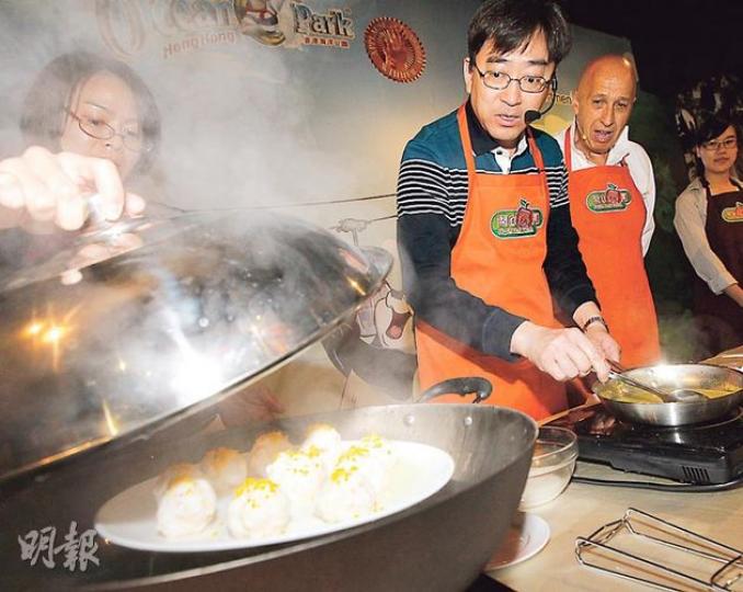 食物及衛生局長高永文(中)噚日出席活動,即場伙拍海洋公園主席盛智文(右)下廚,煮咗道經佢改良嘅潮州菜「蜜柑釀蝦棗」,將柑粒混入蝦丸內,以蒸代炸煮出健康菜式。(李紹昌攝) 食物及衛生局長高永文(中)噚日出席活動,即場伙拍海洋公園主席盛智文(右)下廚,煮咗道經佢改良嘅潮州菜「蜜柑釀蝦棗」,將柑粒混入蝦丸內,以蒸代炸煮出健康菜式。(李紹昌攝)
