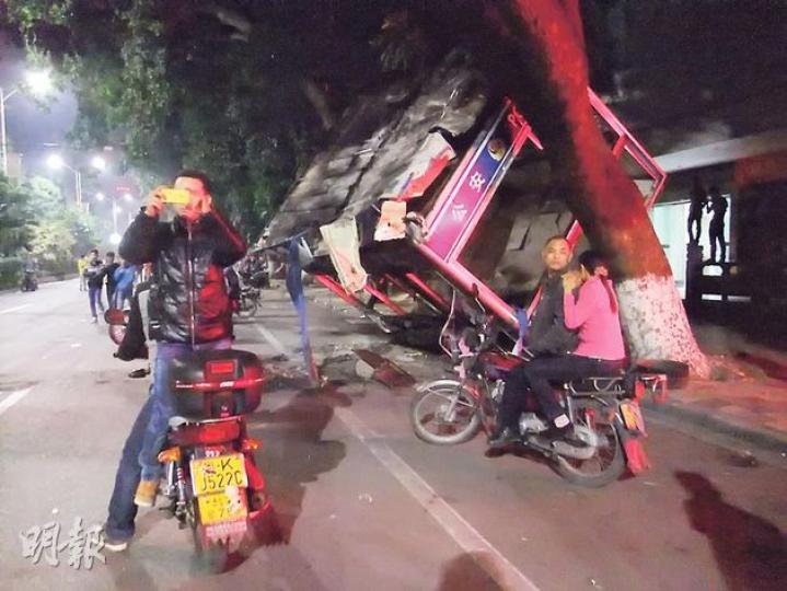 有民眾稱參與打砸的人都是一些飛車黨，「不代表茂名市民」。圖為前晚茂名人民南路近千名市民上街示威，一個警亭被人群打砸並掀翻。警方隨後發射催淚彈驅散示威民眾。（明報記者攝）廣東茂名市區前晚繼續有群眾聚集，明湖商場門前燈柱被人群推倒。（明報記者攝）