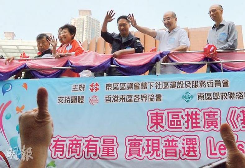 政務司長林鄭月娥（左二橙衫者）昨率領問責班子21名成員乘開篷巴士，到港島東區宣傳政改，參與的包括律政司長袁國強（右三）、政制及內地事務局長譚志源（右二）及環境局長黃錦星（右一）。（盧翊銘攝）政務司長林鄭月娥（左二）昨到天后宣傳政改，其間有庇理羅士女子中學中二生林同學（左三）上前合照。林同學被記者問到是否希望有權提名特首候選人時點頭，說特首提名應「沒有規限」，而林太聽罷即繼續發言，指政改方案要在《基本法》框架下進行。（盧翊銘攝）