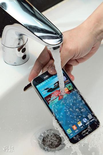 S5沒有抗水柱認證,但記者以水冲測試,仍然運作正常。(林俊源攝) S5沒有抗水柱認證,但記者以水冲測試,仍然運作正常。(林俊源攝)