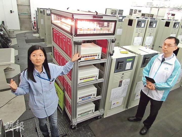 機電署助理電氣督察陸婉明（左）及機管局飛行區機電工程維修助理經理李柱文（右）表示，「跑道燈測試儀器」（圖中發光物）可模擬跑道燈的運作，令工程人員可在室內測試CCR是否正常運作。（黃俊鋒攝）