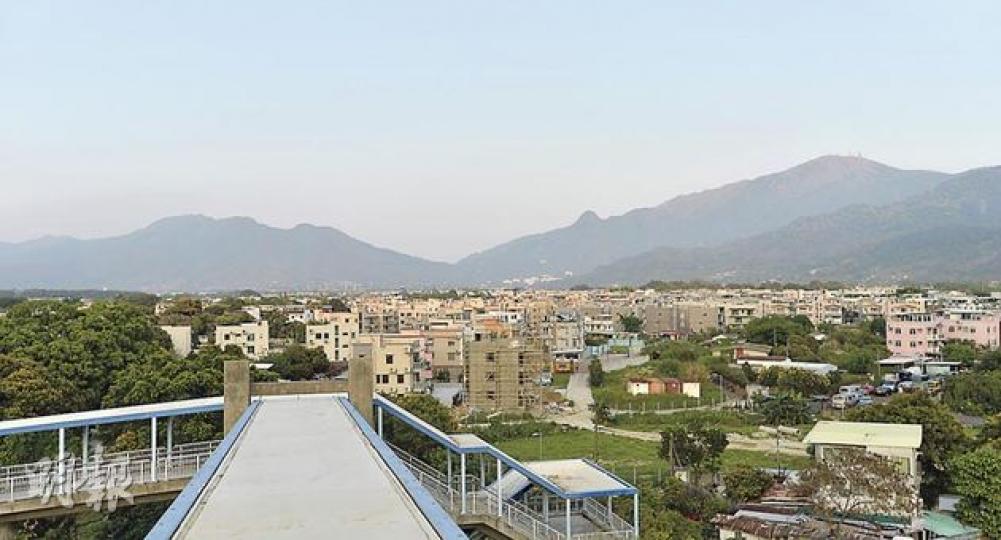 政府計劃在港鐵錦上路站附近發展大型住宅區，勢影響周邊非原居民村落。圖為從港鐵錦上路站向石崗軍營方向眺望，圖中所見的房屋大多位於受影響範圍。（鄧宗弘攝）