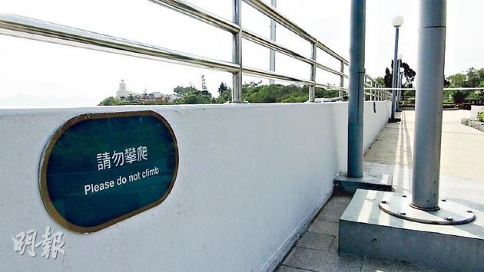 圍欄的石牆上，貼有「請勿攀爬」字句的警告牌，提醒遊客勿攀上欄杆上。（林智傑攝）