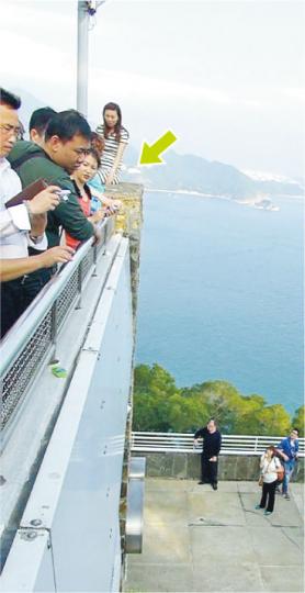 雖然早上曾發生奪命墮地意外，但有內地女遊客為求與海景合照，昨午仍冒險攀上石壆危坐（箭嘴示）。（林智傑攝） 海洋公園昨有內地遊客坐在平台欄杆（圖上方），不慎向後跌墮11米下行人通道地面重傷不治，幸未有傷及其他人。（葉家豪攝）