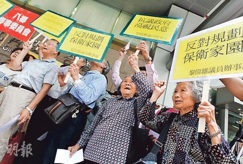 規劃署完成錦田南和八鄉的土地用途研究，並就建議諮詢城規會。百多名錦田和八鄉村民昨趁城規會開會到場抗議，批評規劃署未有諮詢他們，反對有關建議。他們手持橫額，高叫口號，批評當局計劃興建超過3萬個住宅單位，不先聽最受影響的居民意見，反而先諮詢城規會，認為做法不尋常。有村代表指政府在規劃建樓前，必須先做好交通配套。（李紹昌攝）