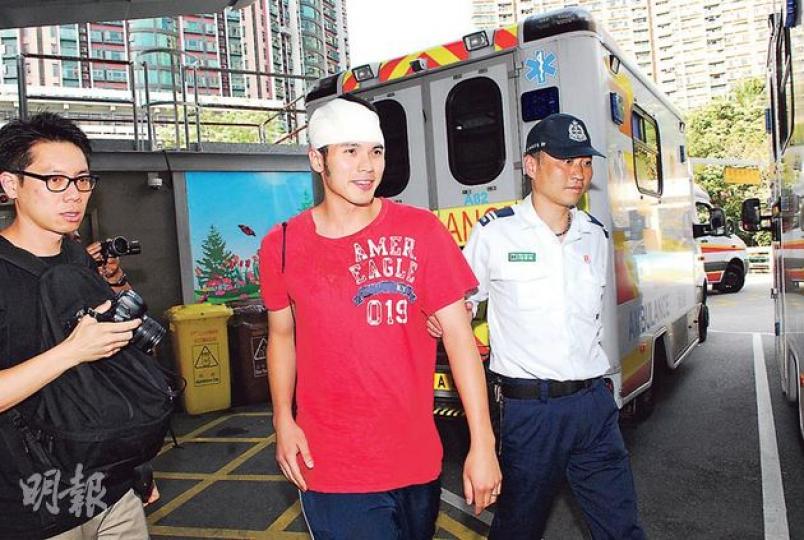 頭部被高處墜下的木方擊中受傷的簡家銘，入院時面帶笑容，向在場記者連番說﹕「無事、無事。」（鍾炳然攝）