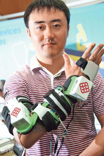 理大生物醫學工程團隊上月研發出靠電極刺激手臂肌肉的「復康袖」，該手袖由5個可分拆的綁帶套件組成，可強化中風患者的手肘、手腕及手指伸展能力。圖為工作人員示範佩戴約重700克的復康袖。 （林俊源攝）