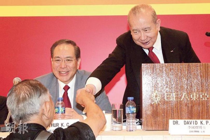 東亞銀行噚日開股東大會，主席李國寶（右）雖然冇正面回應賣盤同繼承問題，不過佢對小股東有講有笑，仲同佢哋握手。（林俊源攝）